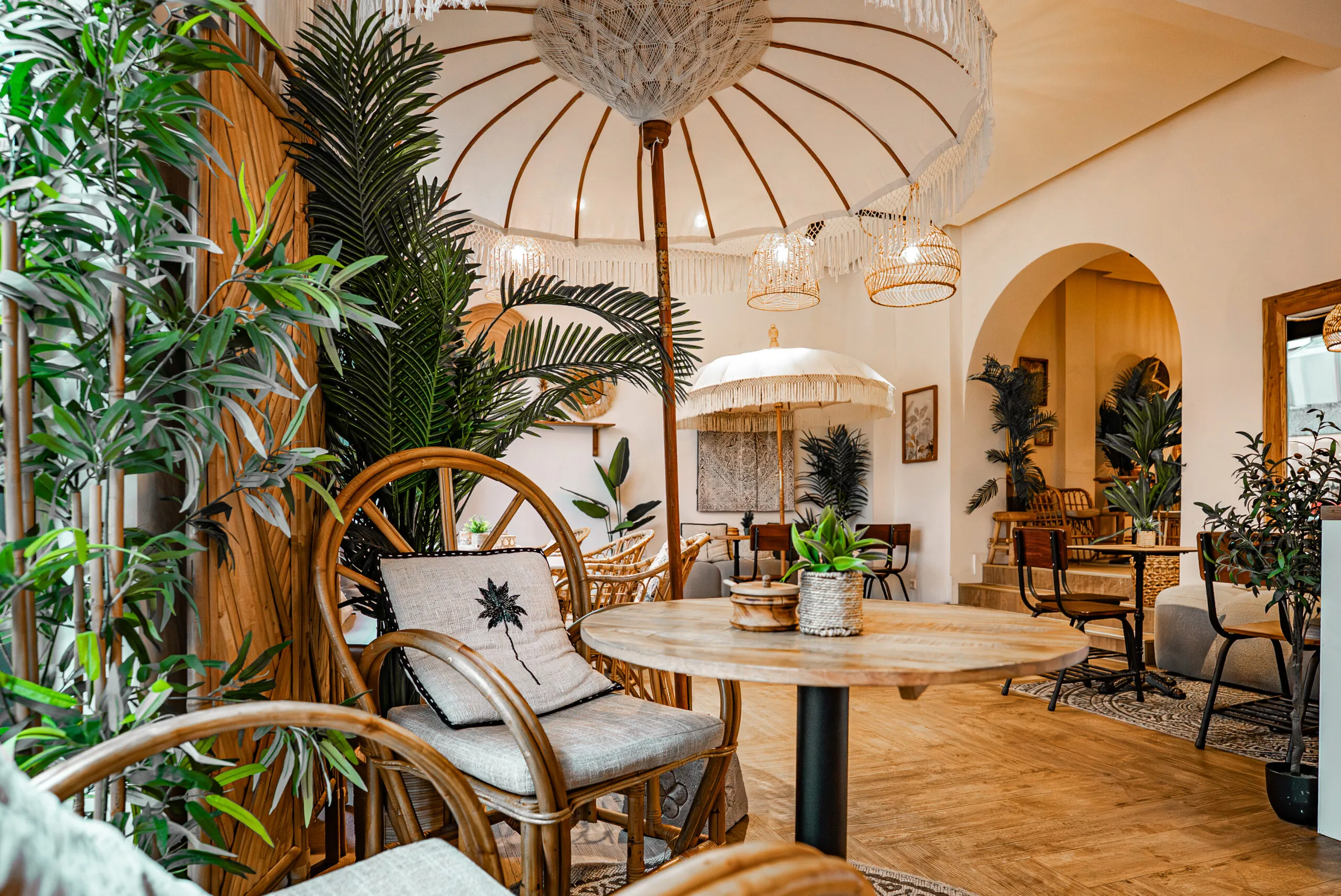 Sitzecke im Sorella Buer mit Rattansessel, Palmenkissen und Sonnenschirm