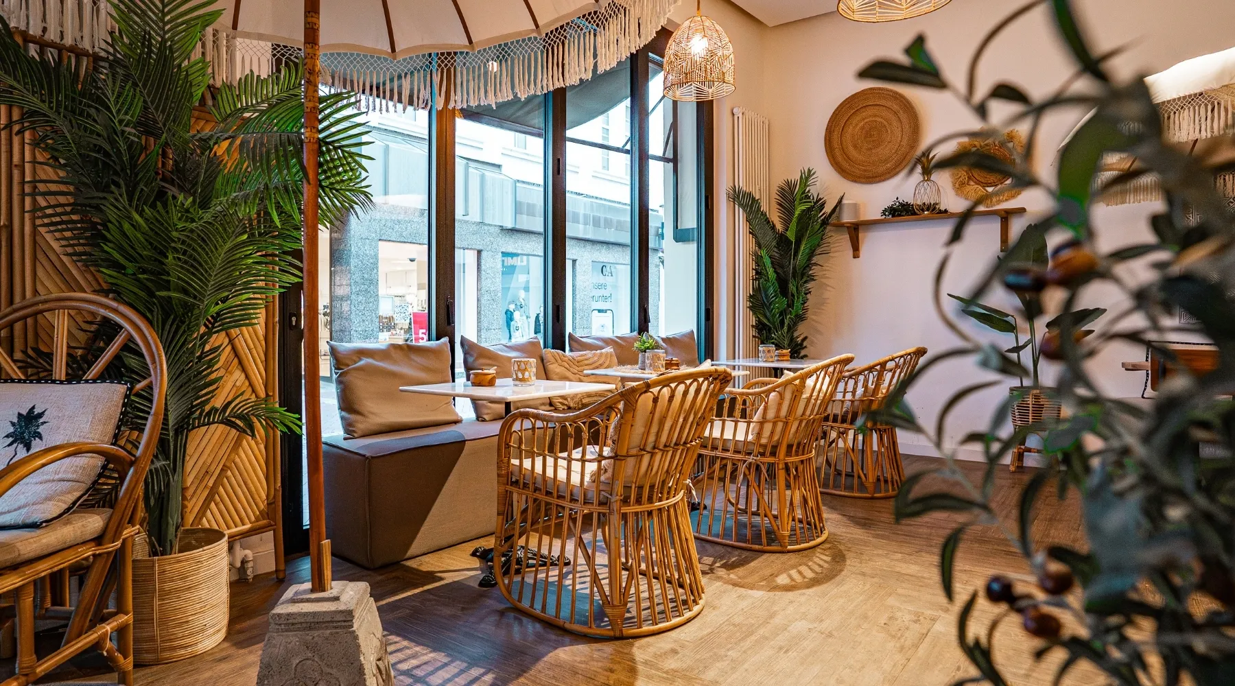 Bänke und Rattansessel unter der Fensterfront im Sorella Buer