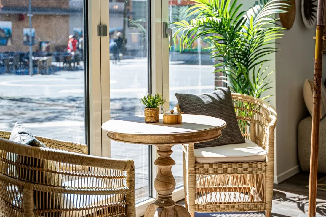 Runder Holztisch mit Rattansesseln an der Fensterfront des Sorella Gladbeck