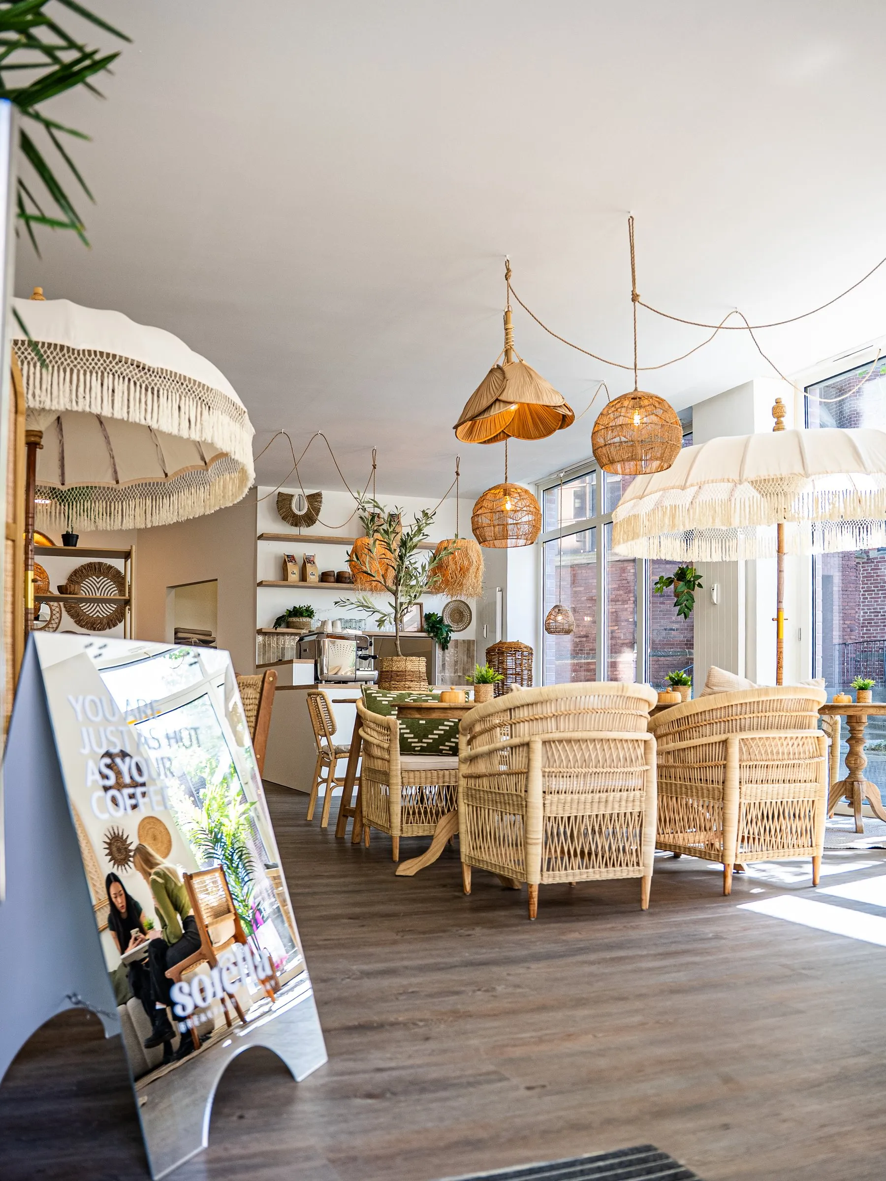 Sitzbereich im Sorella Gladbeck mit Rattansesseln, Fransenlampen und einem Aufsteller an der Theke