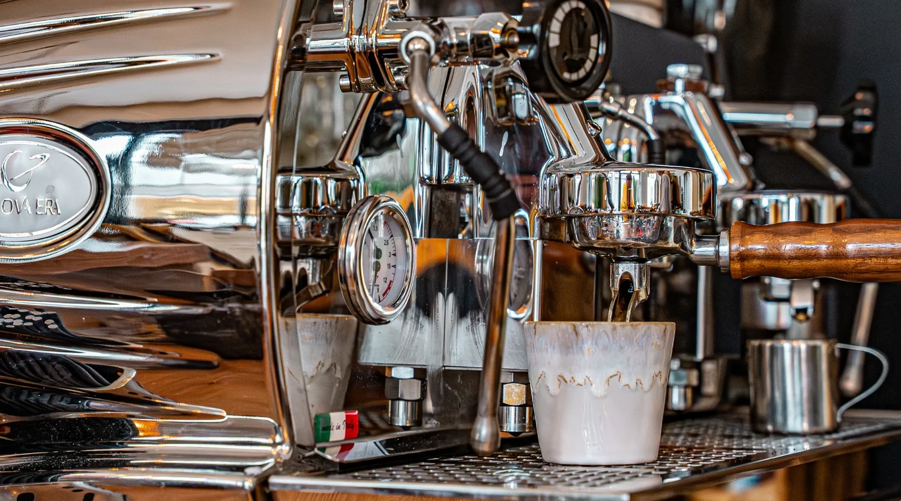 Siebträgermaschine an der Kaffeebar, darunter eine Tasse