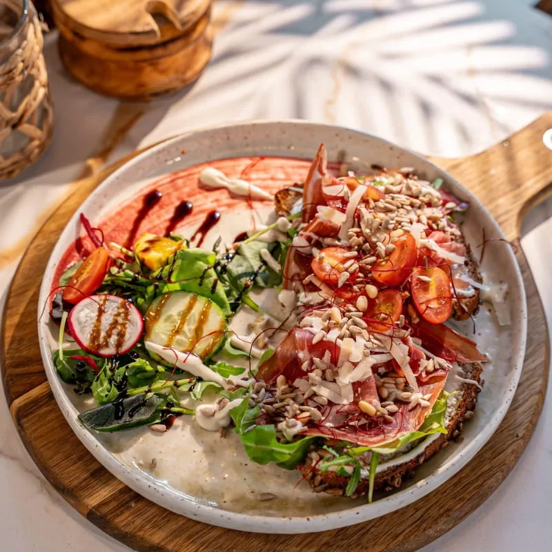 Frühstücksteller mit Salat, Radieschen und Granatapfel