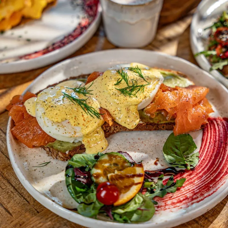 Eggs Benedict mit Räucherlachs und Hollandaise auf geröstetem Brot