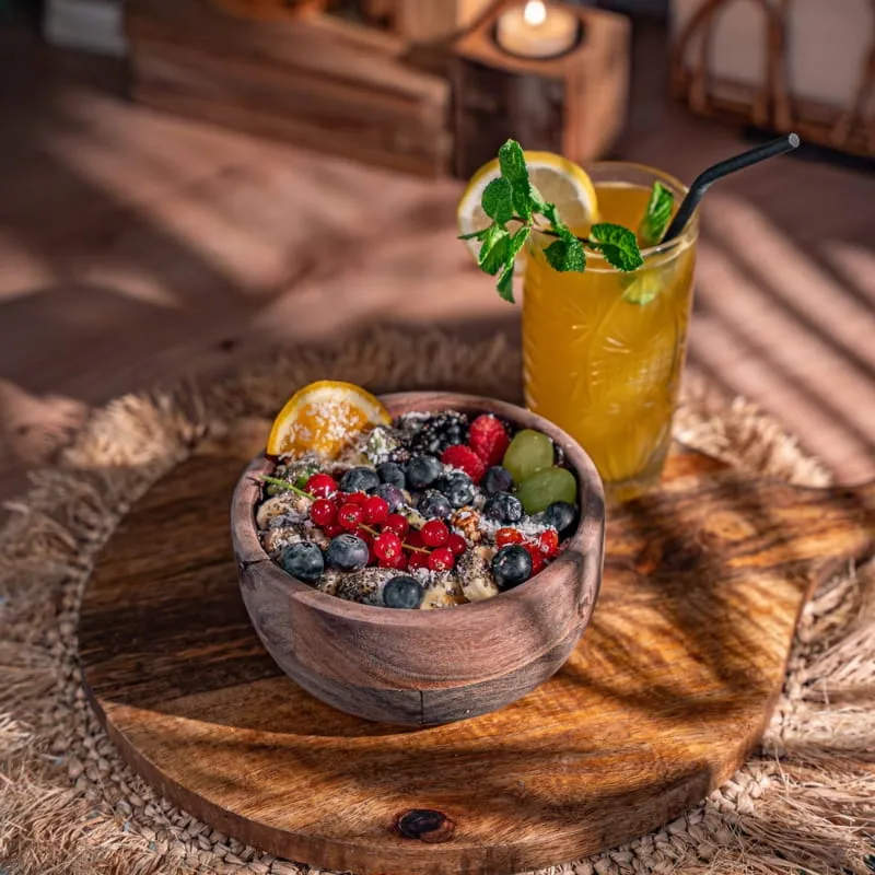 Schale mit Beeren und Chia, daneben eine Limonade mit Minze